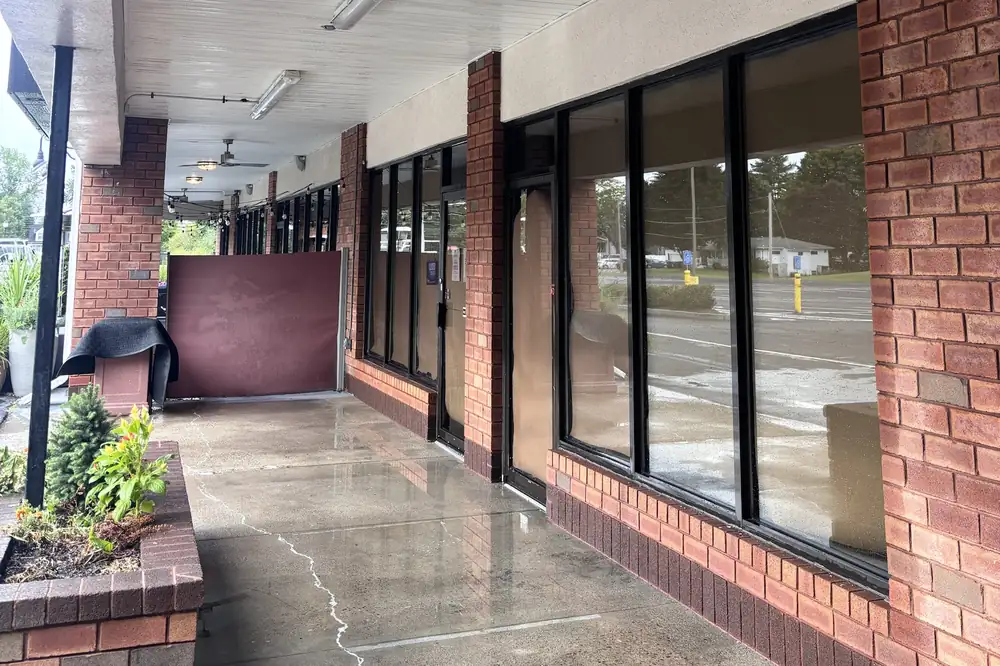 Covered walkway and brick storefront at a commercial plaza